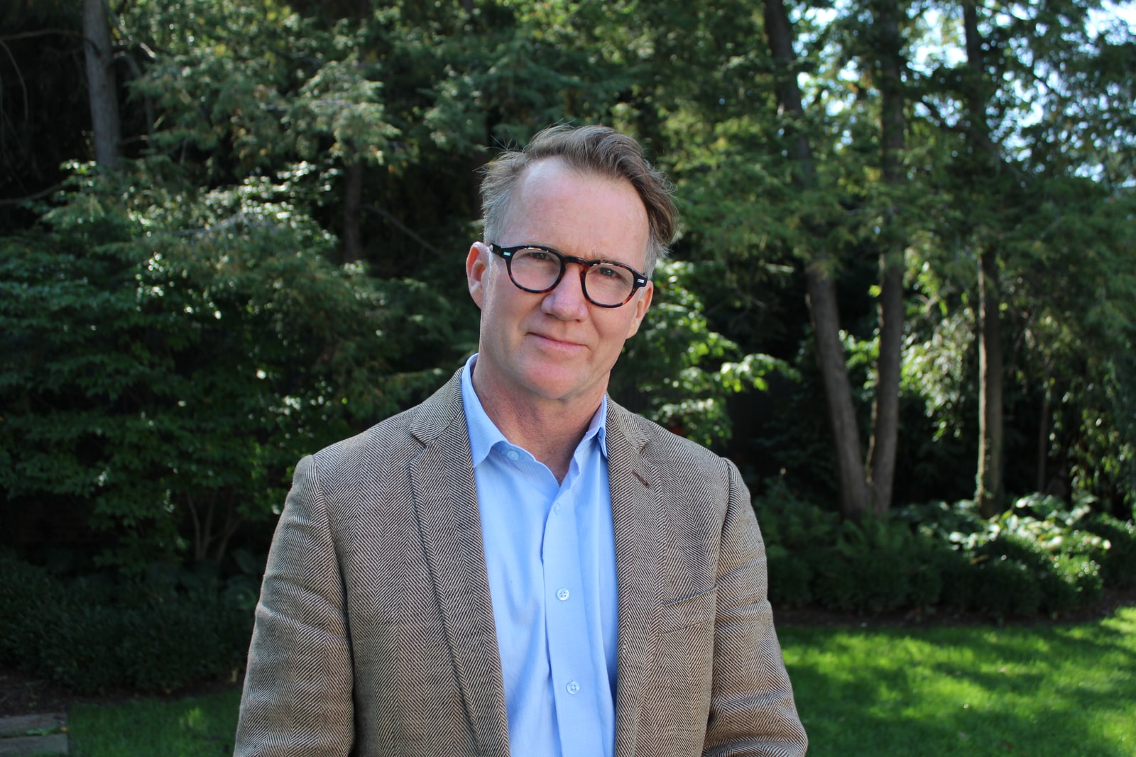 man in brown suit jacket wearing eyeglasses